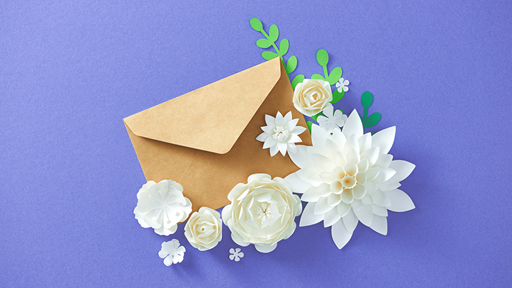 brown envelope on purple background surrounded by flowers