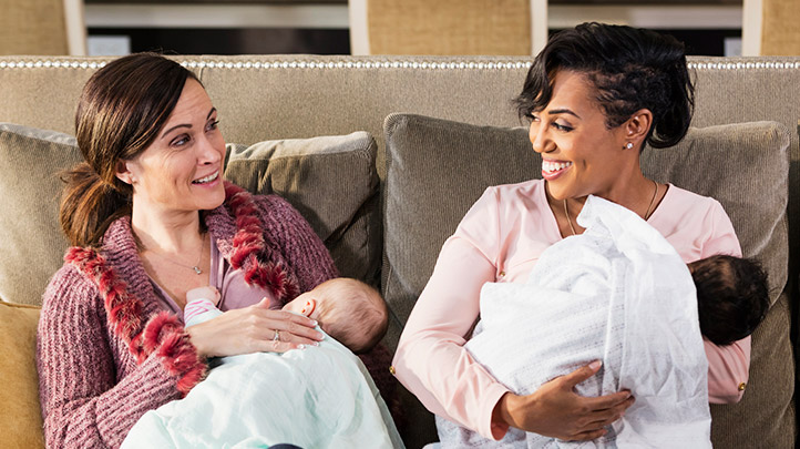 breastfeeding support group, two moms nursing next to each other and smiling