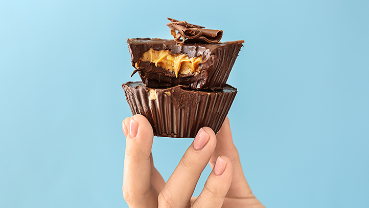 food cravings and aversions during pregnancy, hand holding peanut butter cups