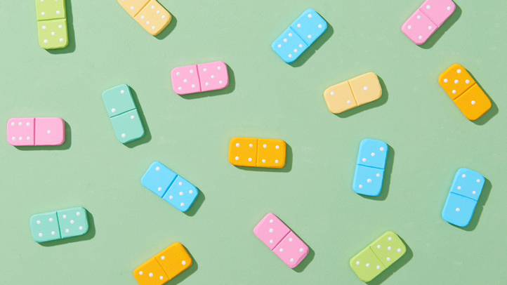 gender reveal ideas, colorful blue and pink dominos on a green background