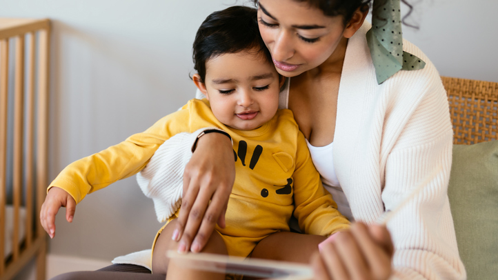 how to sleep train a toddler, mom reading toddler boy a book at bedtime