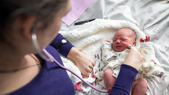 what is a midwife, doctor or midwife examining newborn baby