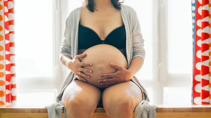 pregnant woman cradling belly