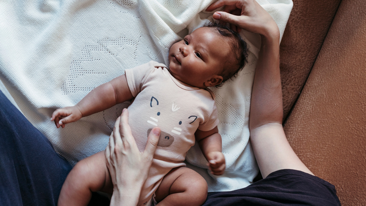 when babies grow hair, mother putting baby down on his back