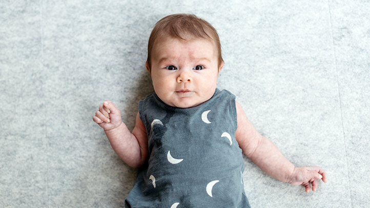 night weaning, how can you wean your baby off night feedings, baby lying down in outfit with moons on it