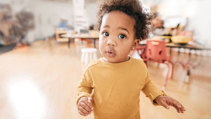 toddler in day care looking surprised, potty accidents in day care or preschool