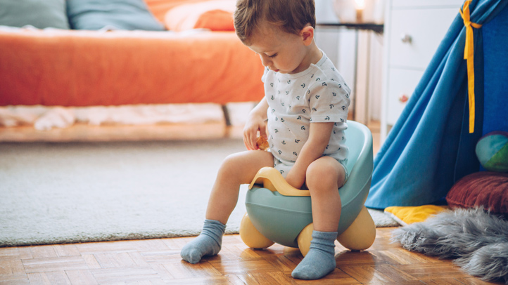 how to potty train a boy, toddler boy sitting on a blue potty