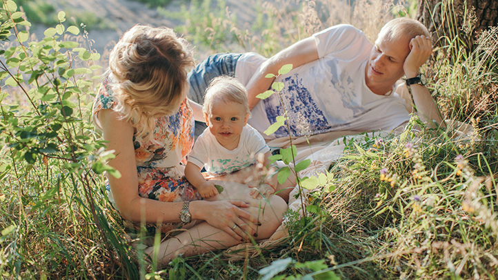 mom, dad and baby in sunny meadow, secondary infertility