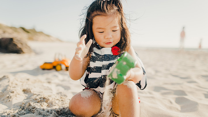 sunscreen and sun protection in toddlers, toddler asian girl at the beach