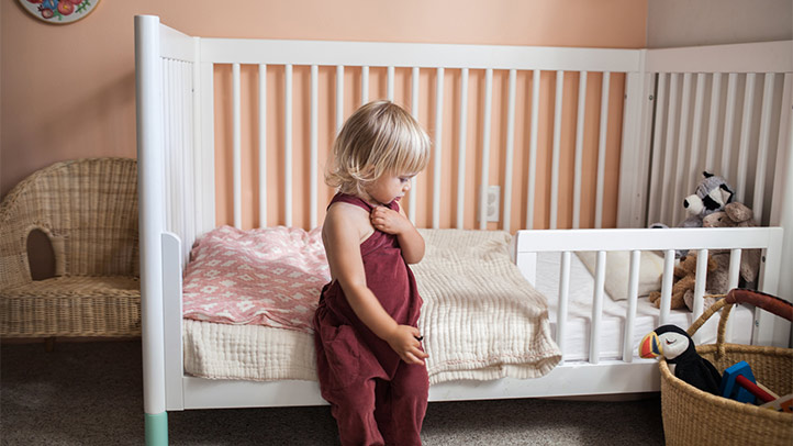 toddler bed safety, switching from crib to toddler bed, little girl in front of a toddler bed