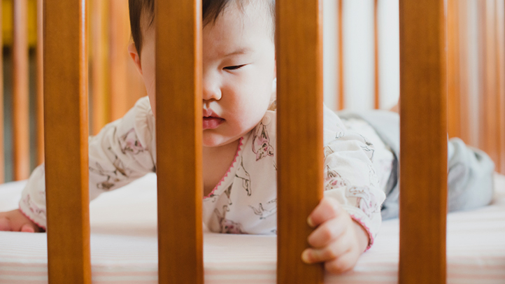 6-month sleep regression in babies, older baby awake on stomach in crib