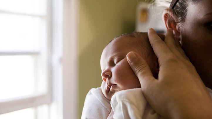 parent holding sleeping baby, how to treat baby's cold