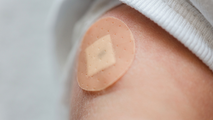 side effects vaccines, child's arm with bandage on it
