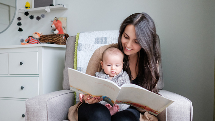 mom reading to baby in nursery