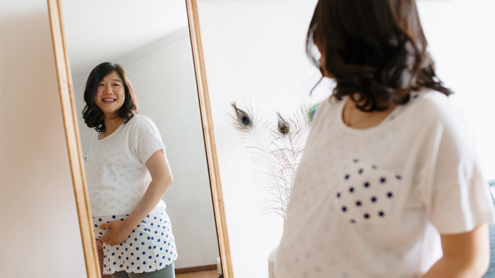 when does baby drop, pregnant woman looking in mirror